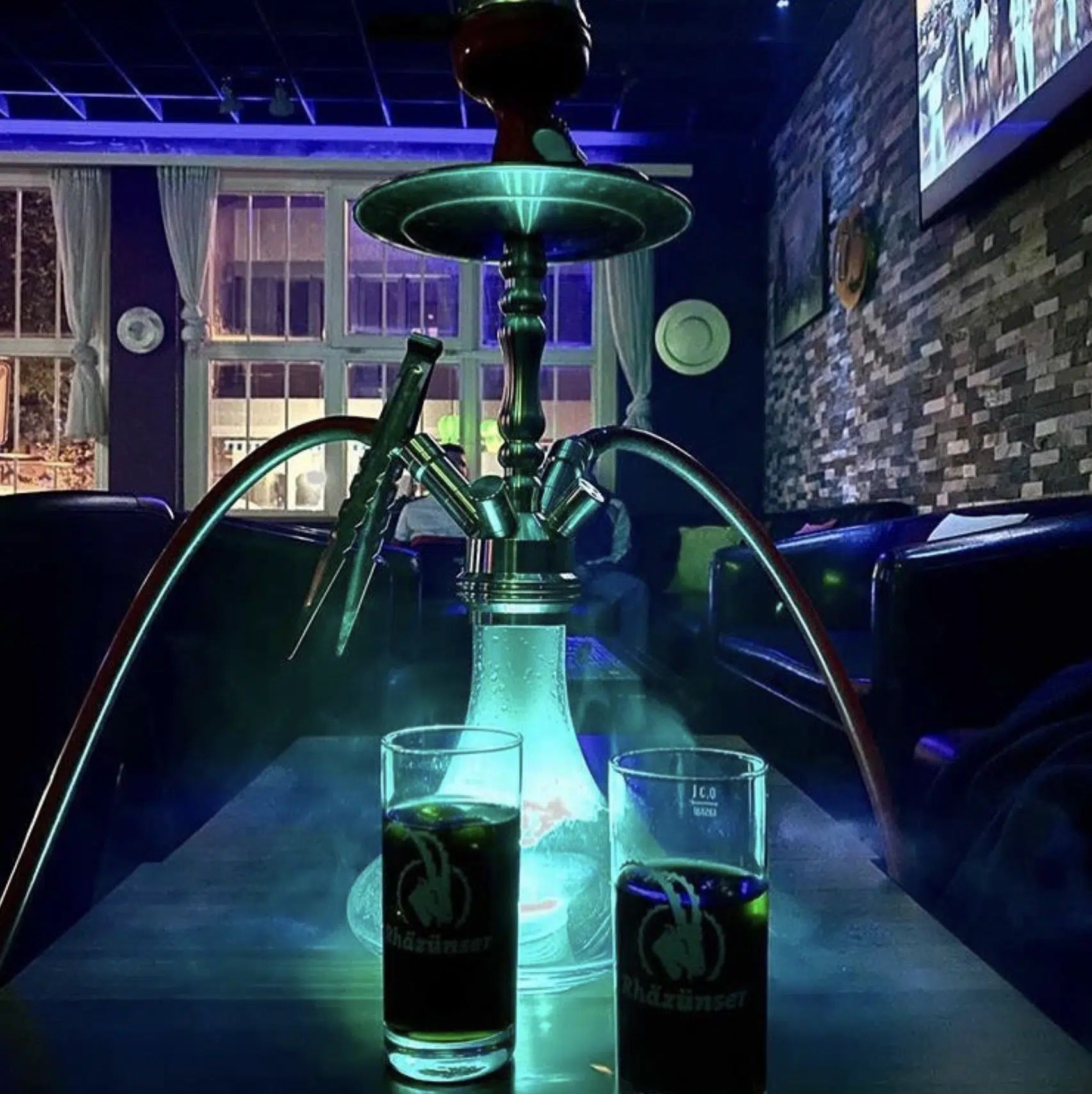 Shisha auf dem Tisch im blau beleuchteten Innenraum der Moe’s Lounge